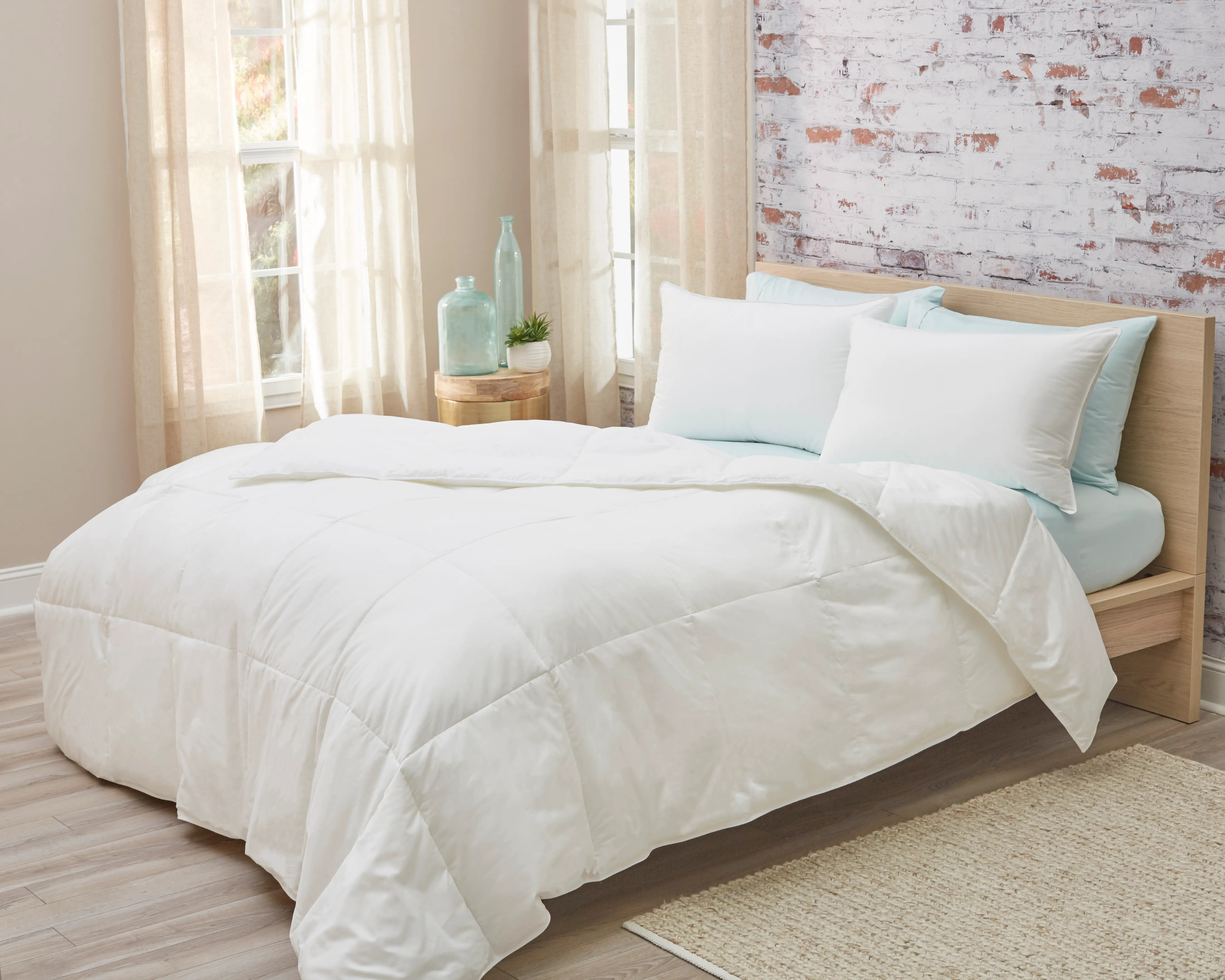 The All Seasons Down Alternative Cotton Comforter on bed with pastel 
